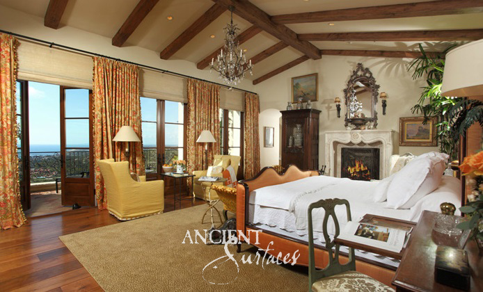 Sculpted limestone bedroom mantel with fine moldings beside French doors opening to a distant ocean view