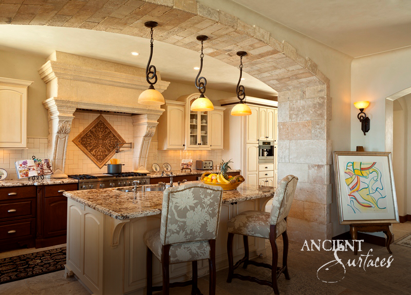 Limestone range hood carved by hand with pilasters beneath a barrel vault of reclaimed limestone voussoirs