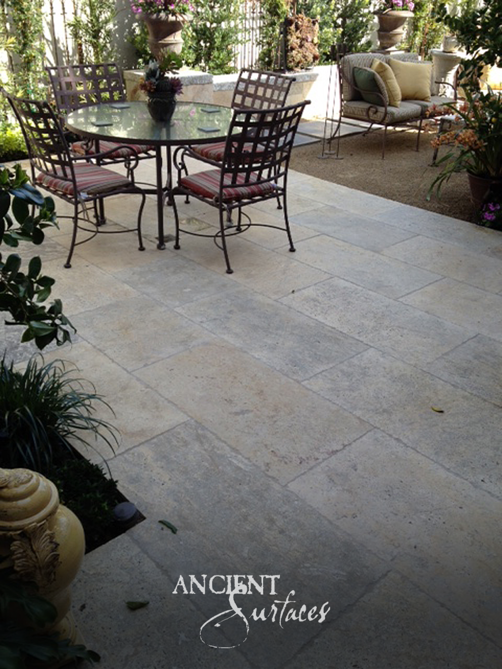 Reclaimed limestone pavers with brushed faces and softened edges laid across a planted garden patio